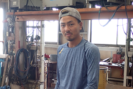 工場の作業場に立つ高野さん